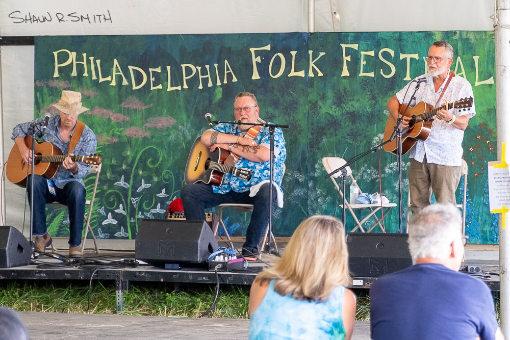 Dave Gunning and J.P. Cormier watch on as Ronald Kushner performs "The Mary Ellen Carter" Sunday, Aug. 18 at the 61st annual Philadelphia Folk Festival (Shaun R. Smith/The High Note).