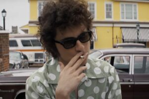 Timothée Chalamet as Bob Dylan stands in front of Congress Hall in Cape May, New Jersey - which features as the setting of the Newport Folk Festival in "A Complete Unknown."